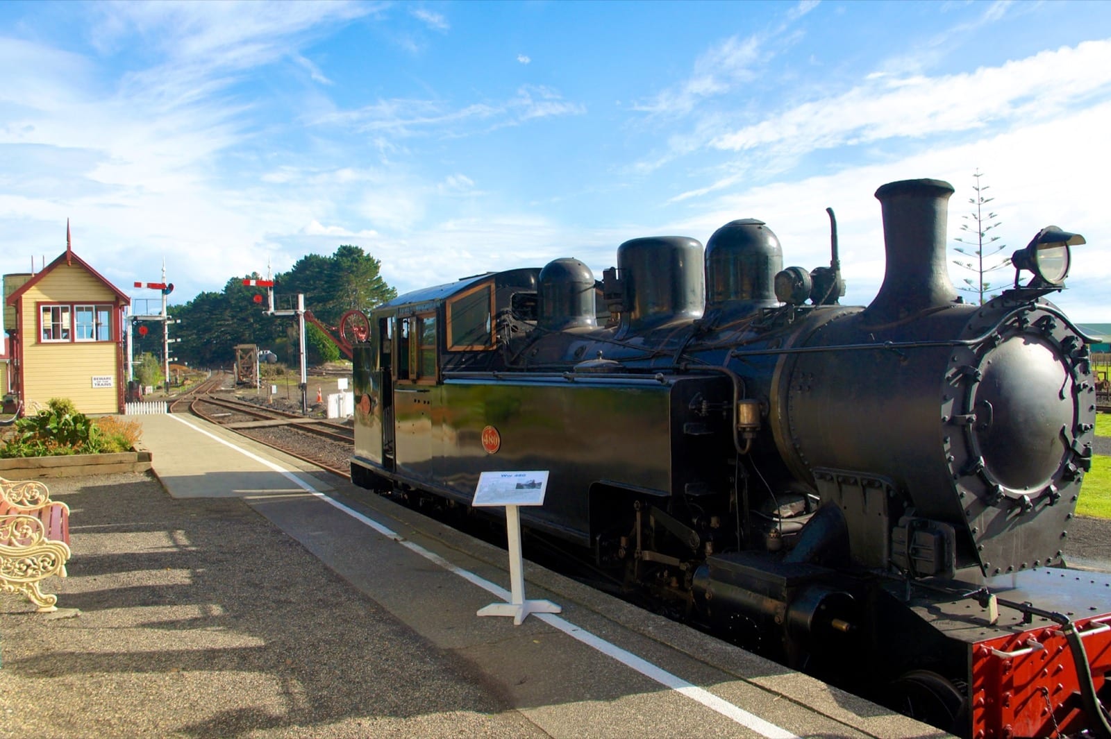 A preserved steam locomotive and signal box at the Glenbrook Vintage Railway station.