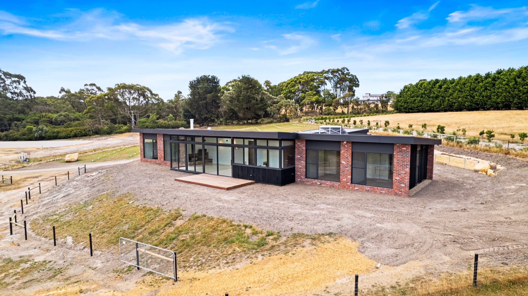 Aerial view of a new house with driveway and landscaping recently completed.