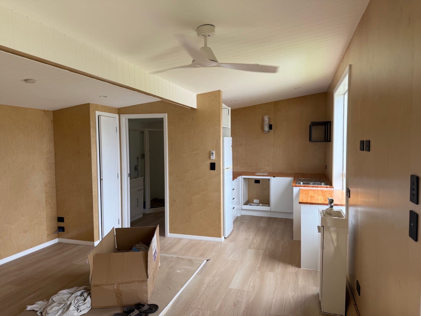 A Backline Construction interior at fit-out stage with kitchen cabinetry going in against finished linings.