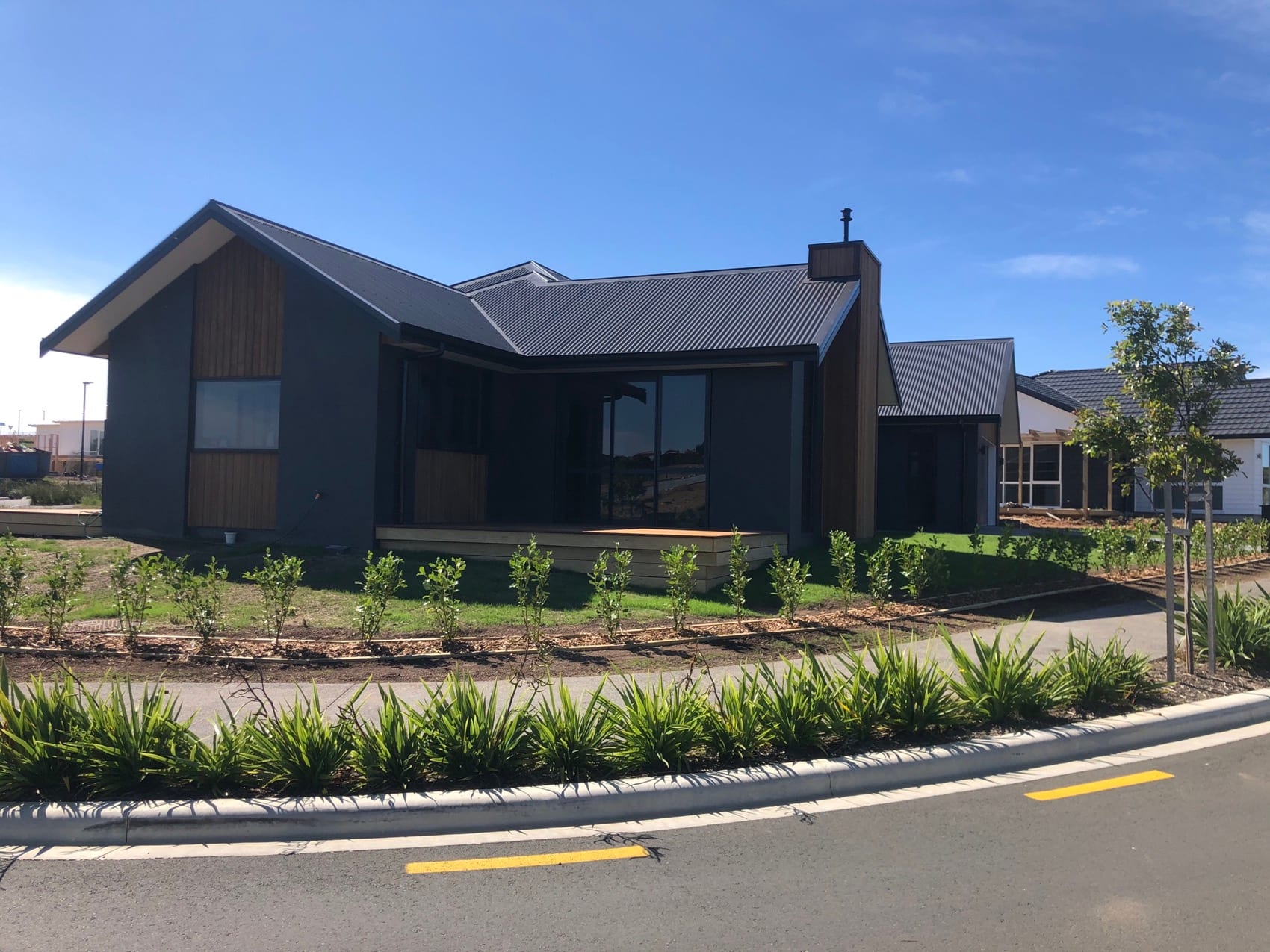 A completed Backline new build seen from the street, with landscaping and planting established.