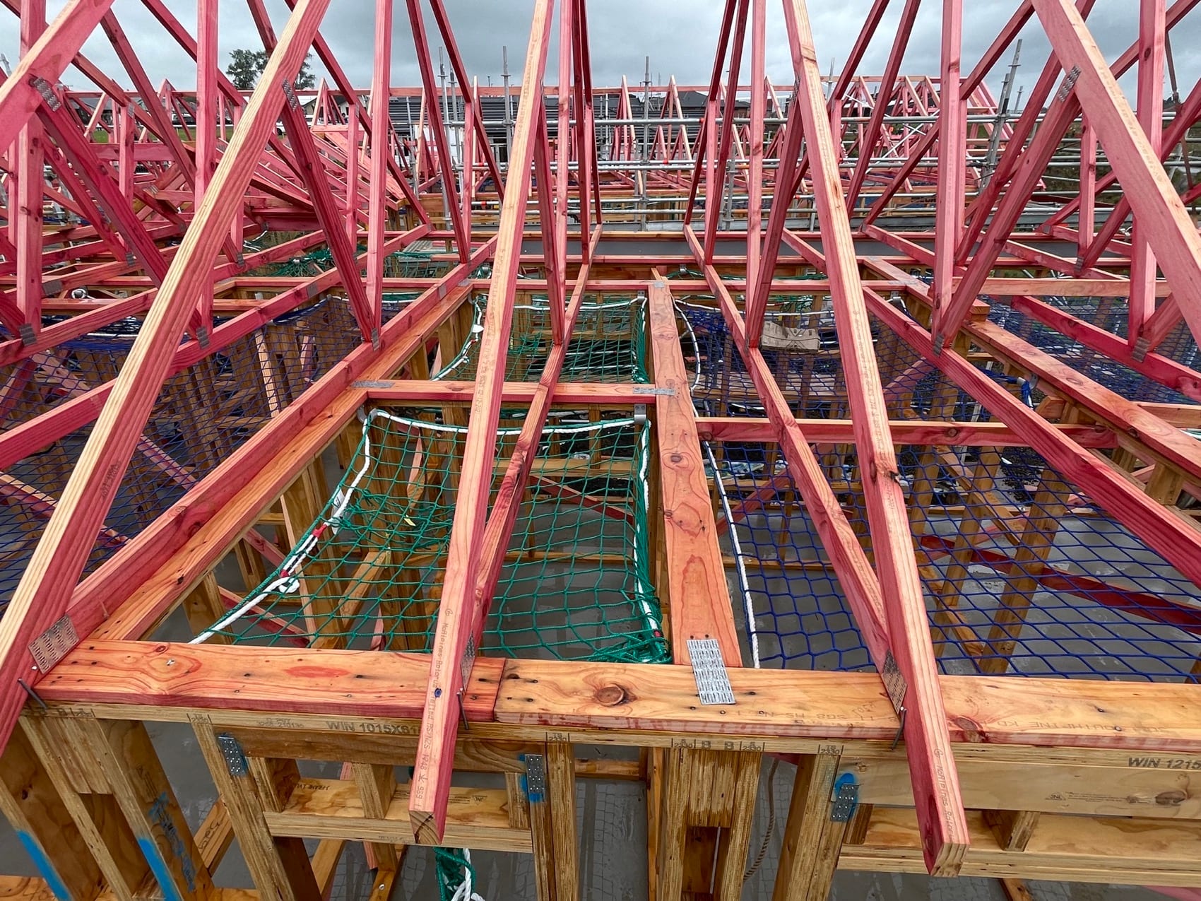 Roof trusses landed and braced across a new build, seen looking down the length of the roof.