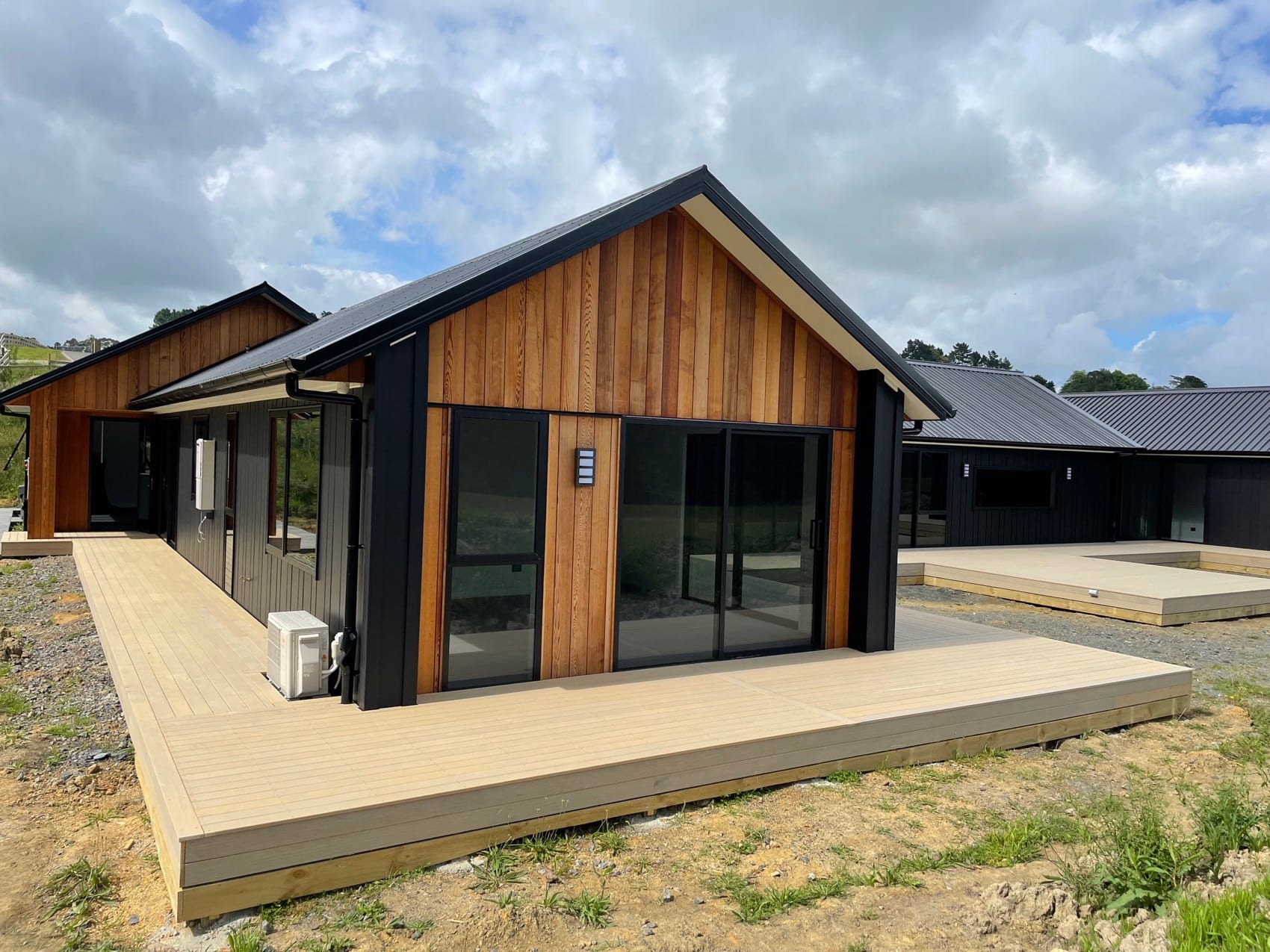The finished gable end of a Backline new build, clad in vertical cedar above a timber deck.