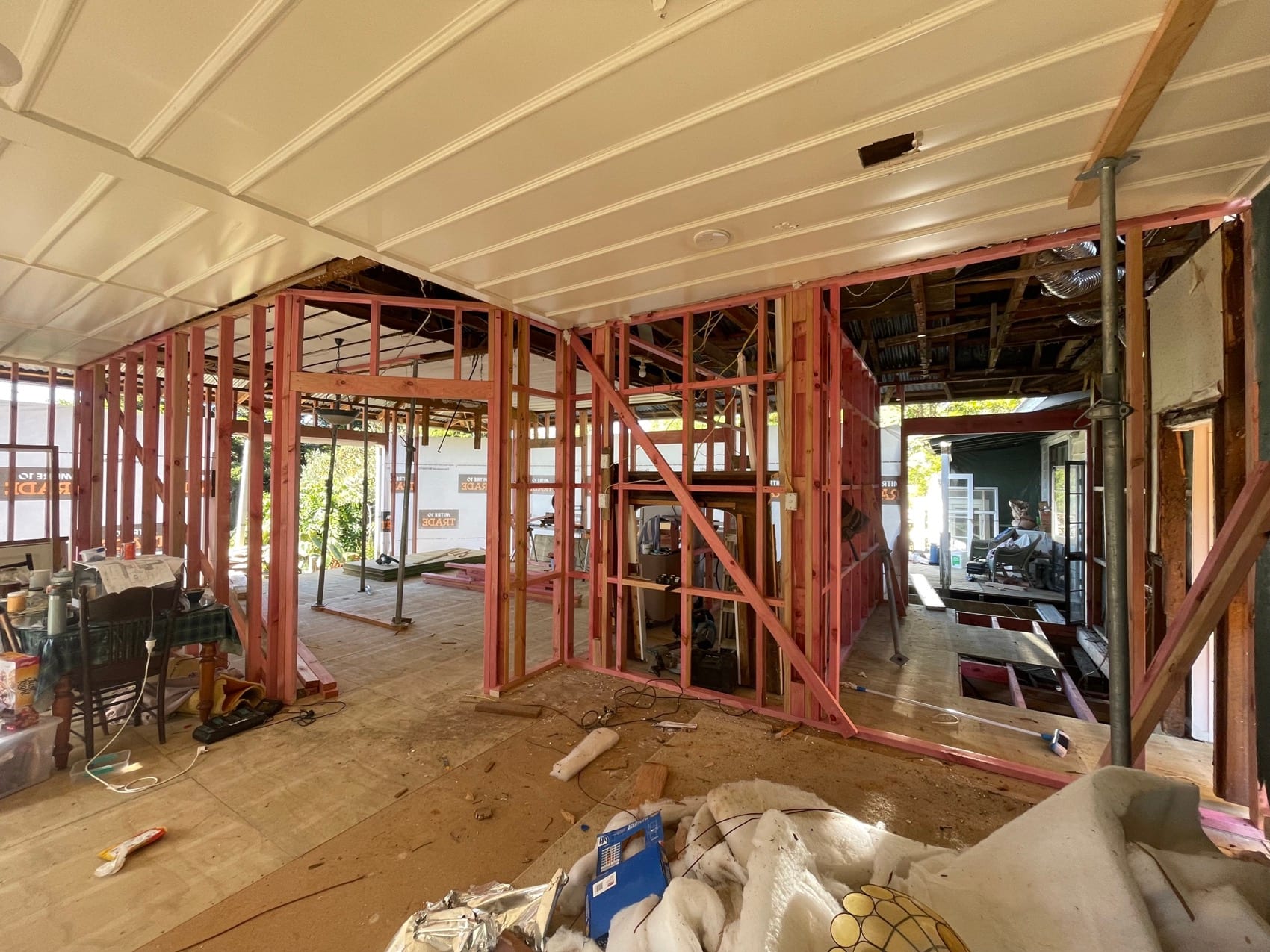 An open-plan space held on steel props after internal walls were removed, framing and services exposed.