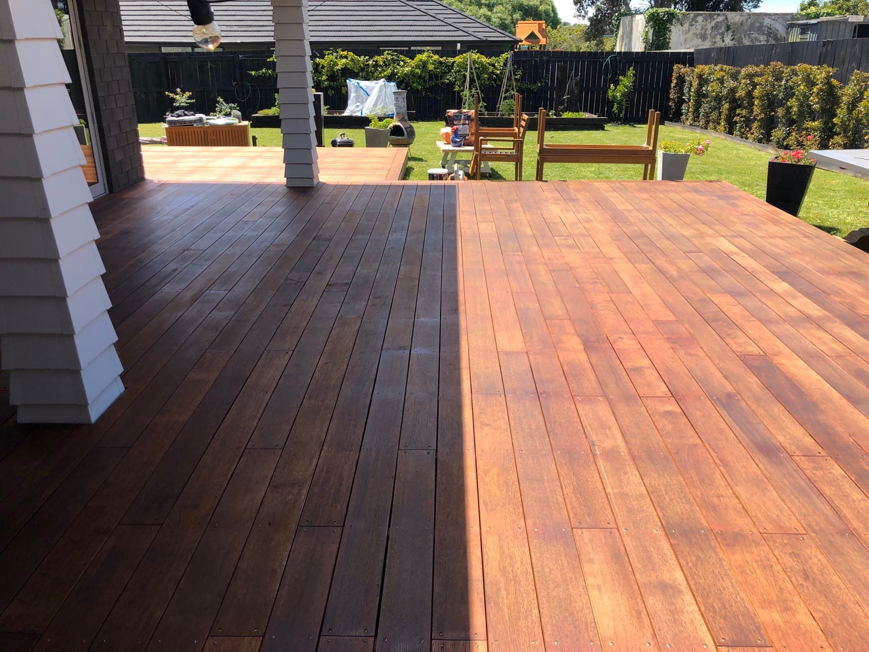 Rich stained decking boards running out from a covered outdoor area.